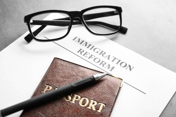 Passport, glasses and sheet of paper with words IMMIGRATION REFORM on table - Fotoğraf, Görsel