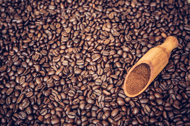 コーヒー豆の背景に木製のスクープ - 写真・画像