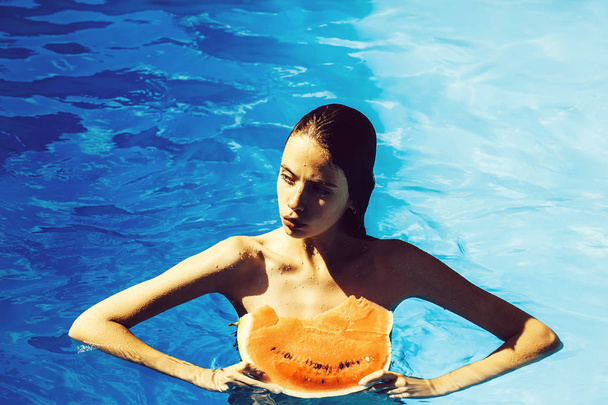 woman with watermelon in swimming pool - Фото, изображение