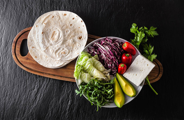 Tortillas flat and various vegetables for tacos or burrito makin - 写真・画像