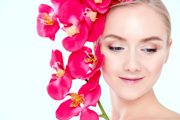 Young beauty woman with flower near face - Zdjęcie, obraz
