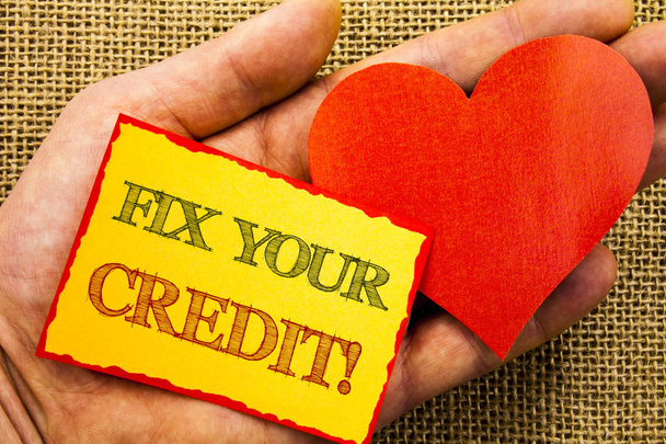 Handwriting text showing Fix Your Credit. Business concept for Bad Score Rating Avice Fix Improvement Repair written on Sticky Note Paper With Heart Holding Hand with Finger. - Photo, Image