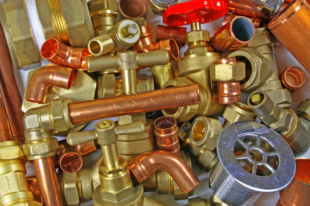 Plumber's pipes and fittings       Random mixture of copper pipe and brass fittings ideal for use as a website header  background - Photo, Image
