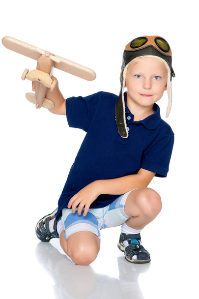 Little boy with a wooden plane. - 写真・画像