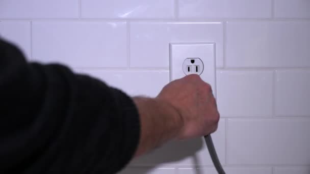 Muž zasune elektrický kabel do kuchyňské zásuvky - Záběry, video