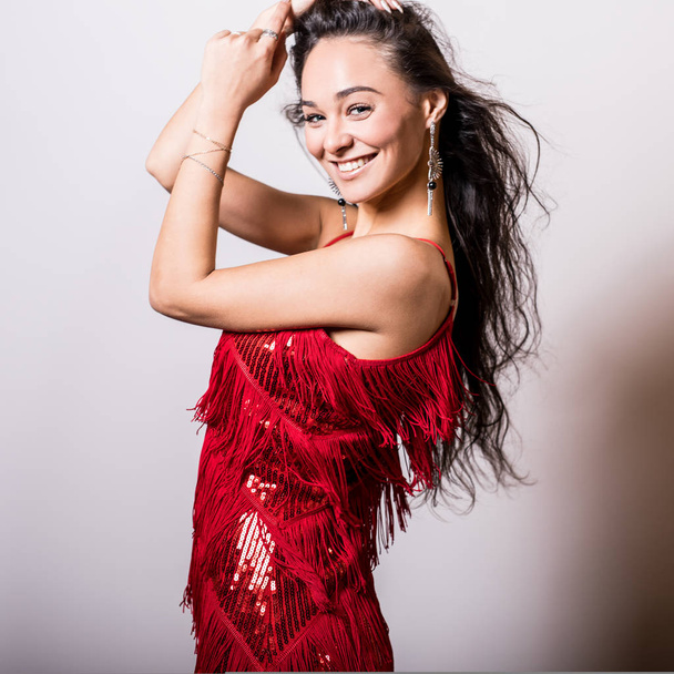 Young sensual woman in red dress pose in studio. - Foto, Bild