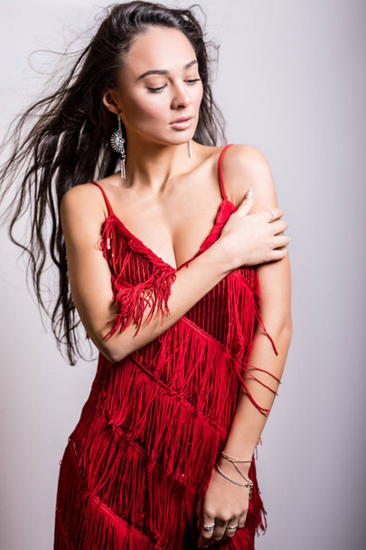 Young sensual woman in red dress pose in studio. - 写真・画像