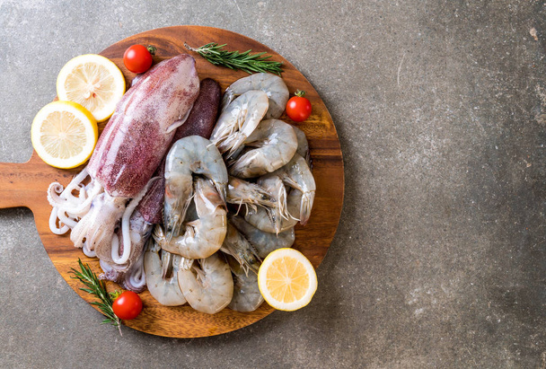 fresh seafood raw (shrimps ,squids) on wooden board  - 写真・画像