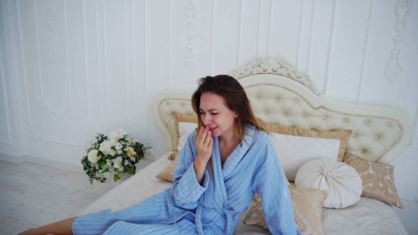 Nők a rossz hangulat, felindulás és sír, ül ágyas tágas hálószoba. - Fotó, kép