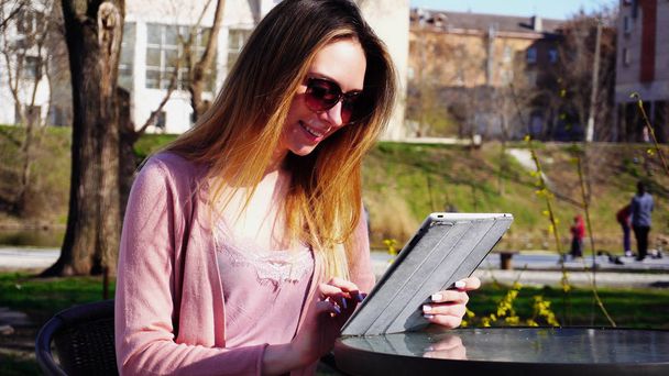 Menina encantadora trabalhando com tablet no parque e descansando no sol gla
 - Foto, Imagem
