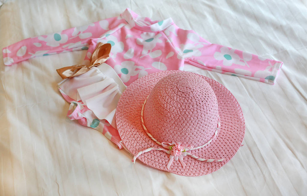 Child swimsuit with hat on the bed ready go to the sea - Foto, Bild