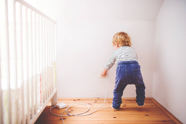 Toddler boy in a dangerous situation at home. - Foto, afbeelding