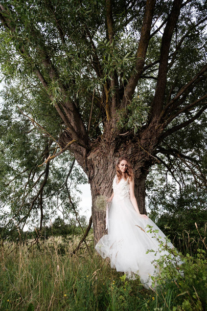 νεαρή όμορφη νύφη στο λευκό νυφικό σε εξωτερικούς χώρους, συνθέτουν και  - Φωτογραφία, εικόνα