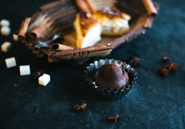 Cake on a wooden tray on a black matte background - 写真・画像