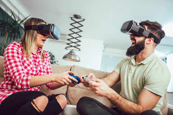 Onnellisia ystäviä pelaa videopelejä virtuaalitodellisuus lasit - Nuoret hauskaa uuden teknologian konsoli verkossa - Valokuva, kuva