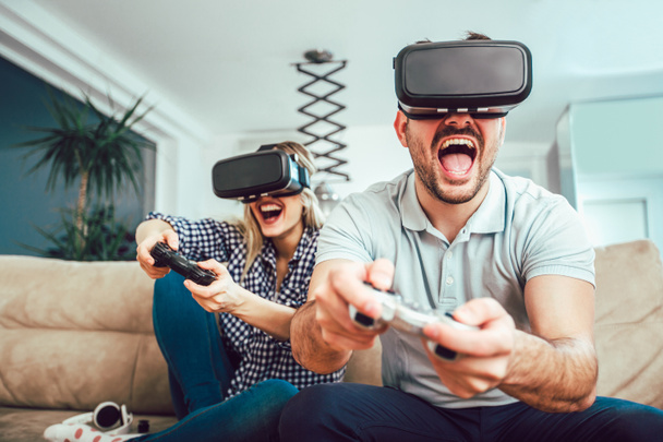 Szczęśliwi przyjaciele grający w gry wideo z okularami wirtualnej rzeczywistości - Młodzi ludzie bawiący się z nową konsolą technologiczną online - Zdjęcie, obraz