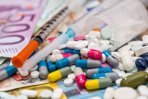 pills  with syringe above euro bills. Medicine cost. - Foto, Imagem