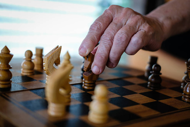 χέρι παίζοντας το παιχνίδι σκάκι. επιχειρηματικό σχέδιο & ανάλυση για την επιτυχία. r - Φωτογραφία, εικόνα