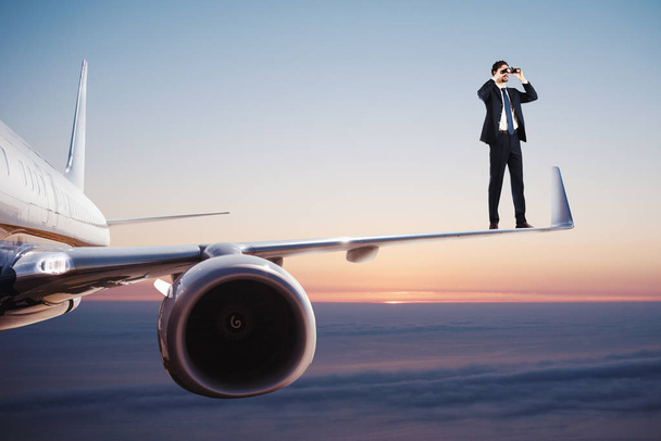 Uomo d'affari con binocolo su un aereo alla ricerca di nuove opportunità di business
 - Foto, immagini