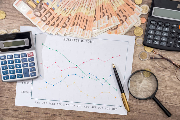 Финансовые концепции - бизнес-график, евро деньги, ручка, увеличительные очки, калькулятор
 - Фото, изображение