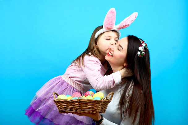 Mom and little girl with a basket of easter eggs  - Photo, Image
