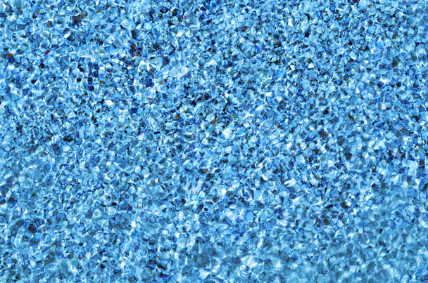 Kristalhelder zeewater rimpelingen mousserende in de zon van de middag. Golfde water met onderkant zand en schelpen gezien onderwater - Foto, afbeelding