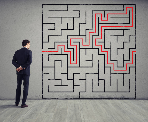 Businessman draws the solution of a labyrinth. Concept of problem solving - Photo, Image
