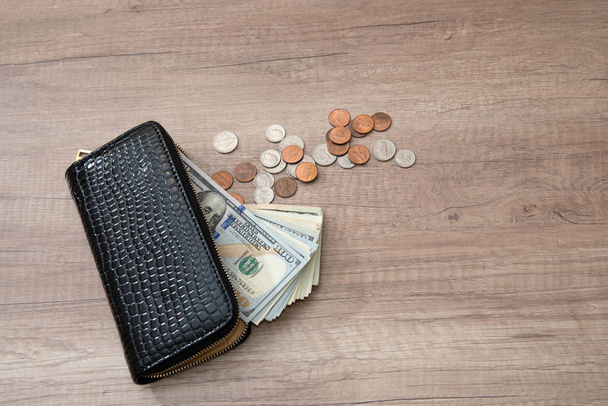 female black wallet with us money on wooden background - Foto, Bild