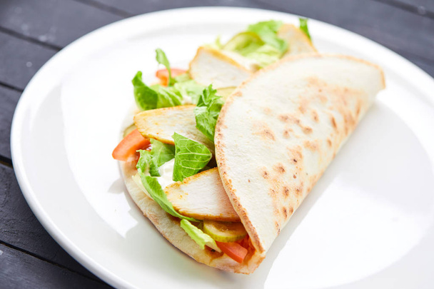 сэндвич с мясом и овощами на белой тарелке, крупным планом
  - Фото, изображение
