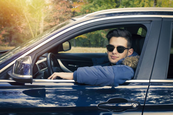 kuljettaja hymyilee autossa
 - Valokuva, kuva