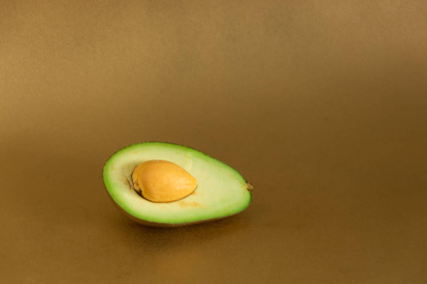 Золотий авокадо в розрізі на золотому фоні
 - Фото, зображення