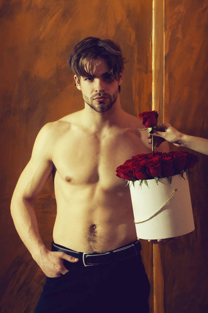 bearded muscular man with sexy body holds red rose box - Fotografie, Obrázek