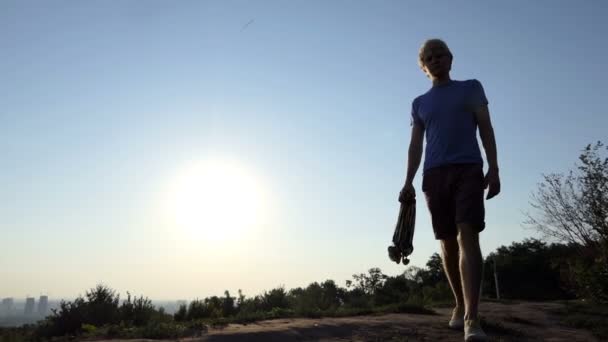 Vaalea mies menee monia mitaleja kädessään auringonlaskun Slo-mo
 - Materiaali, video