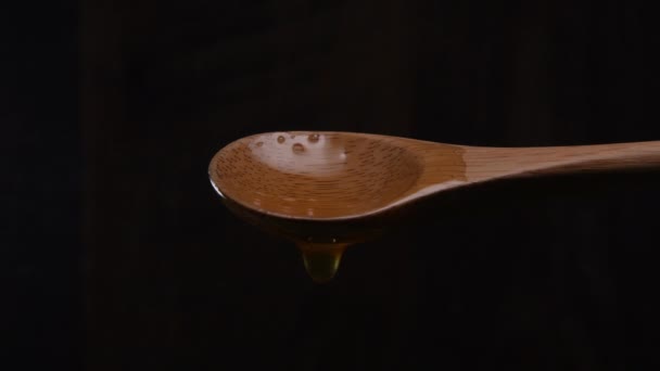 Podświetlany miód powoli kapie z łyżką - Materiał filmowy, wideo