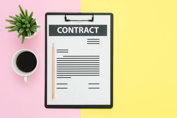 Flat lay design of office desk working space  - Top view of a contract document and coffee cup decorated with small cactus on pink yellow pastel color with copy space. Pastel working space background. - Photo, Image