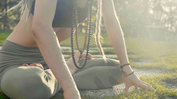 Ejercicio de respiración de yoga Pranayama por una mujer joven en el patio trasero de su casa
. - Foto, Imagen