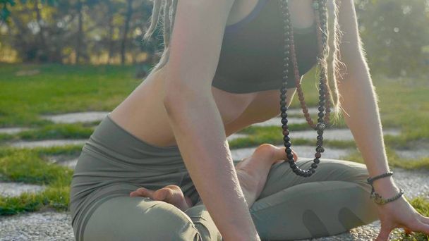 Ejercicio de respiración de yoga Pranayama por una mujer joven en el patio trasero de su casa
. - Foto, Imagen