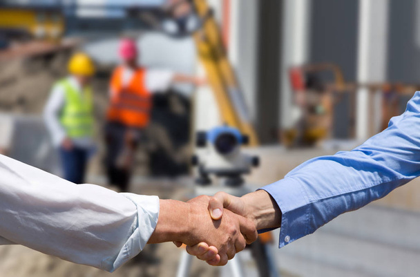 Инженеры пожимают руки на строительной площадке
 - Фото, изображение