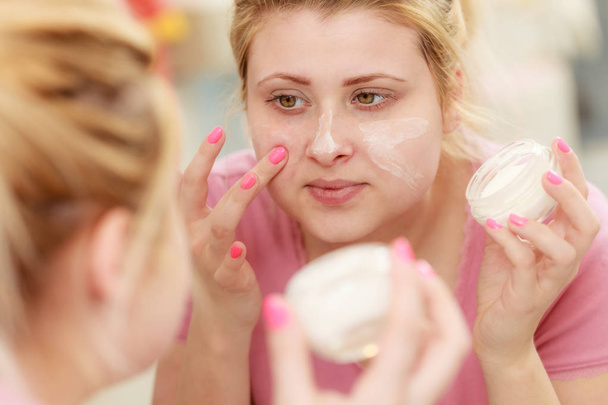 Woman applying face cream with her finger - Photo, Image
