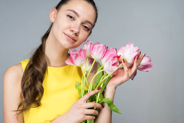 thoughtful woman holding beautiful flowers, tulips on March 8 - Foto, afbeelding