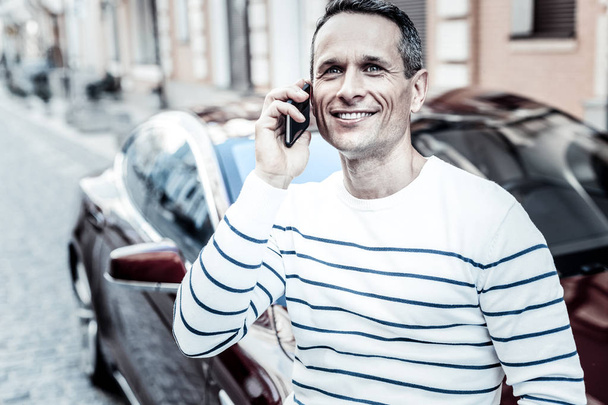 Cheerful happy man having a phone conversation - Фото, зображення