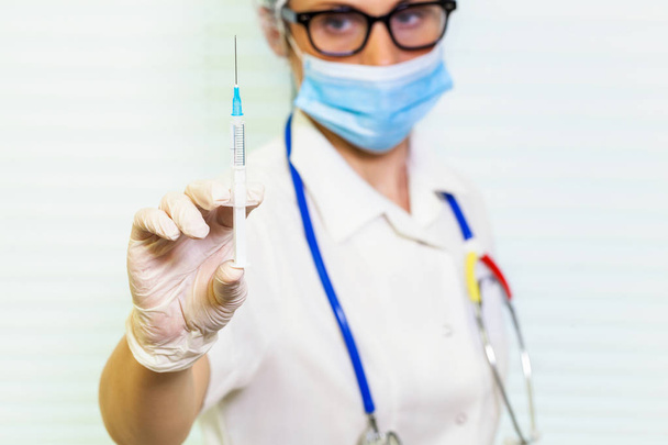 Doctor keeping syringe in room - Foto, Bild