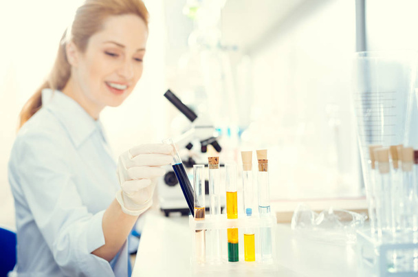 Smiling scientist taking test tube with chemical liquid - Foto, Bild