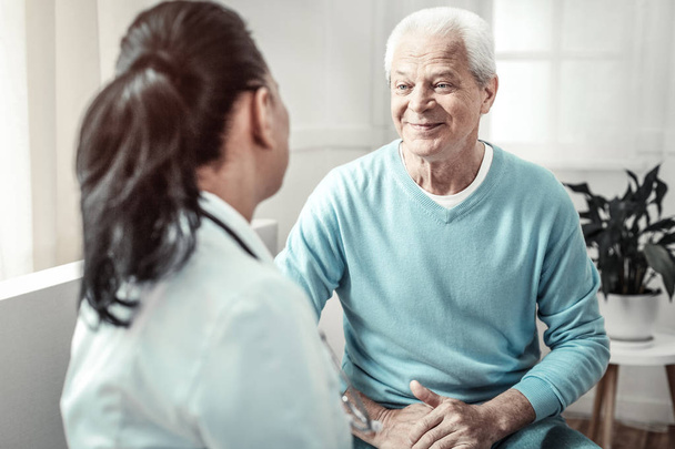 Senior pleasant man sitting and looking at the doctor. - Photo, Image