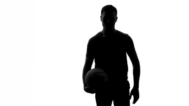 Man bouncing ball and passing it to another player, basketball training, shadow - Video