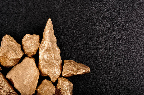 Gold nuggets on a black background leather. Closeup. - Photo, Image