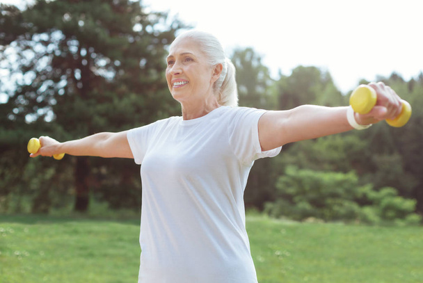 Nice active woman exercising with dumbbells - Fotografie, Obrázek