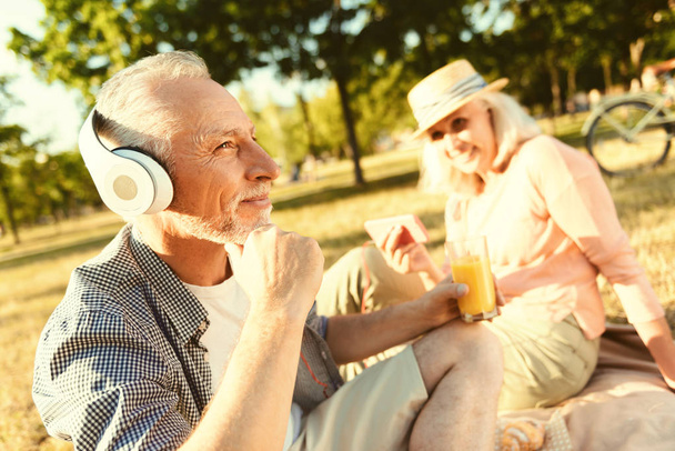 Positiivinen ikäinen mies käyttää kuulokkeita
 - Valokuva, kuva