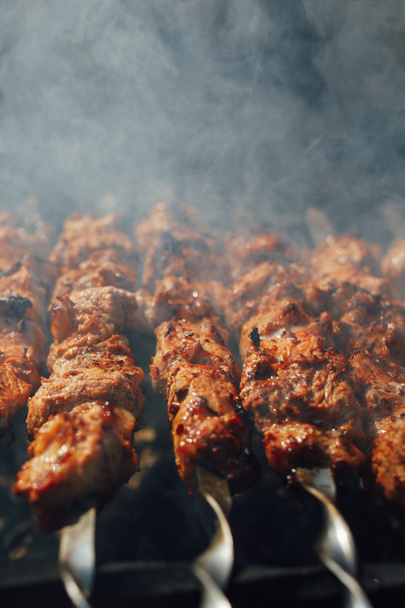grilled barbecue meat on skewers with smoke - Photo, Image