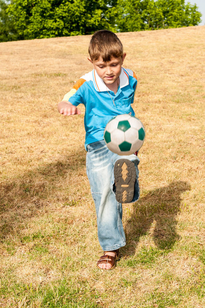 Small footballer hits the ball on goal - Zdjęcie, obraz